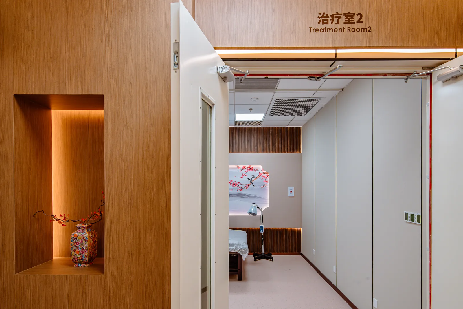 Entrance to a treatment room with warm wood finishes at Beijing Puhua International Hospital.